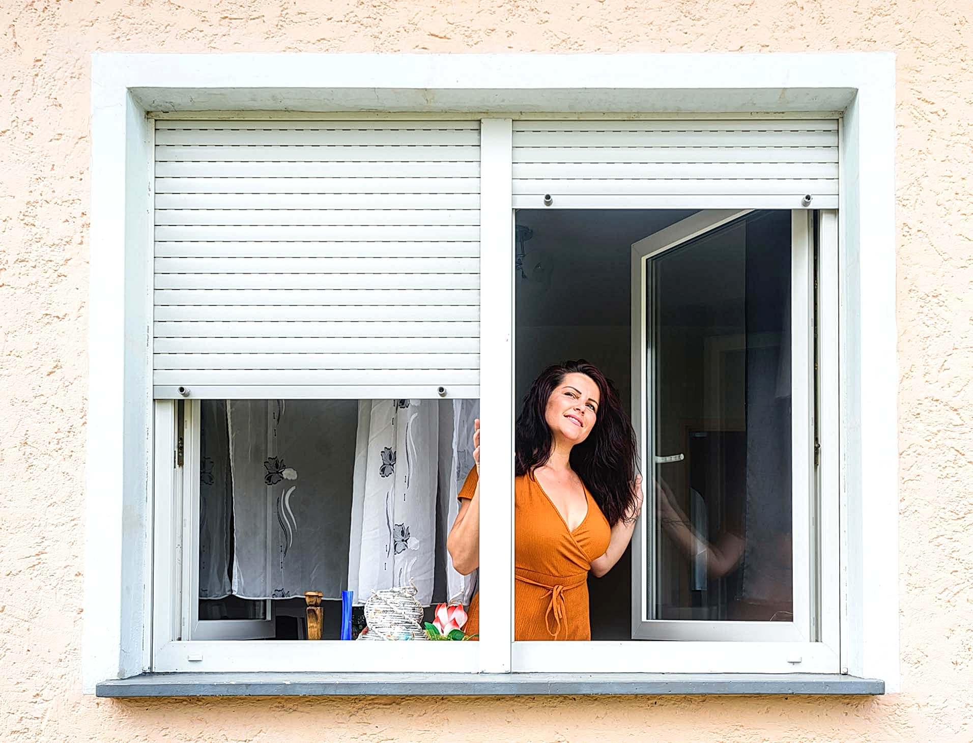 Frau am Fenster Dreh-Kipp-Fenster lassen sich auch vollständig zum Lüften öffnen.
