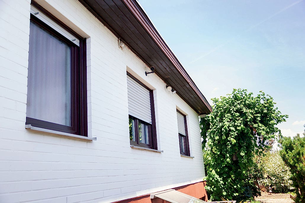 Kunststofffenster in Mahagonioptik bei Familie Skolik Die neuen Fenster aus Kunststoff passen durch die hochwertige Folierung in Mahagoni-Holz-Optik perfekt in das Fassadenbild.