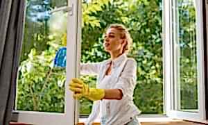 Frau putzt Fenster