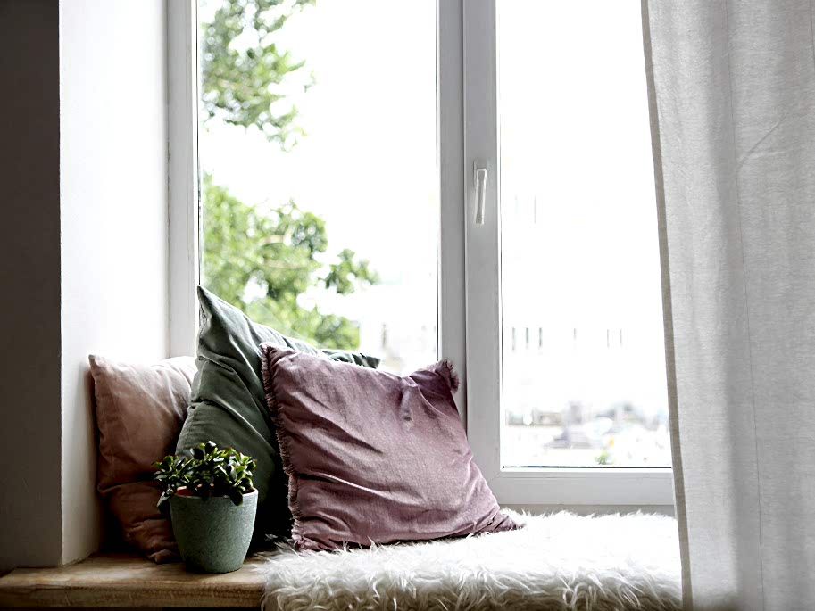 Fensterbank mit Kissen und Decke
